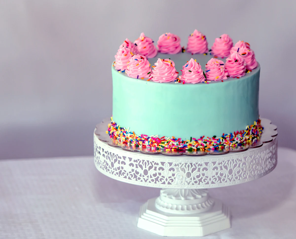 Festliche Torte mit rosa Sahnetupfen und Streuseln