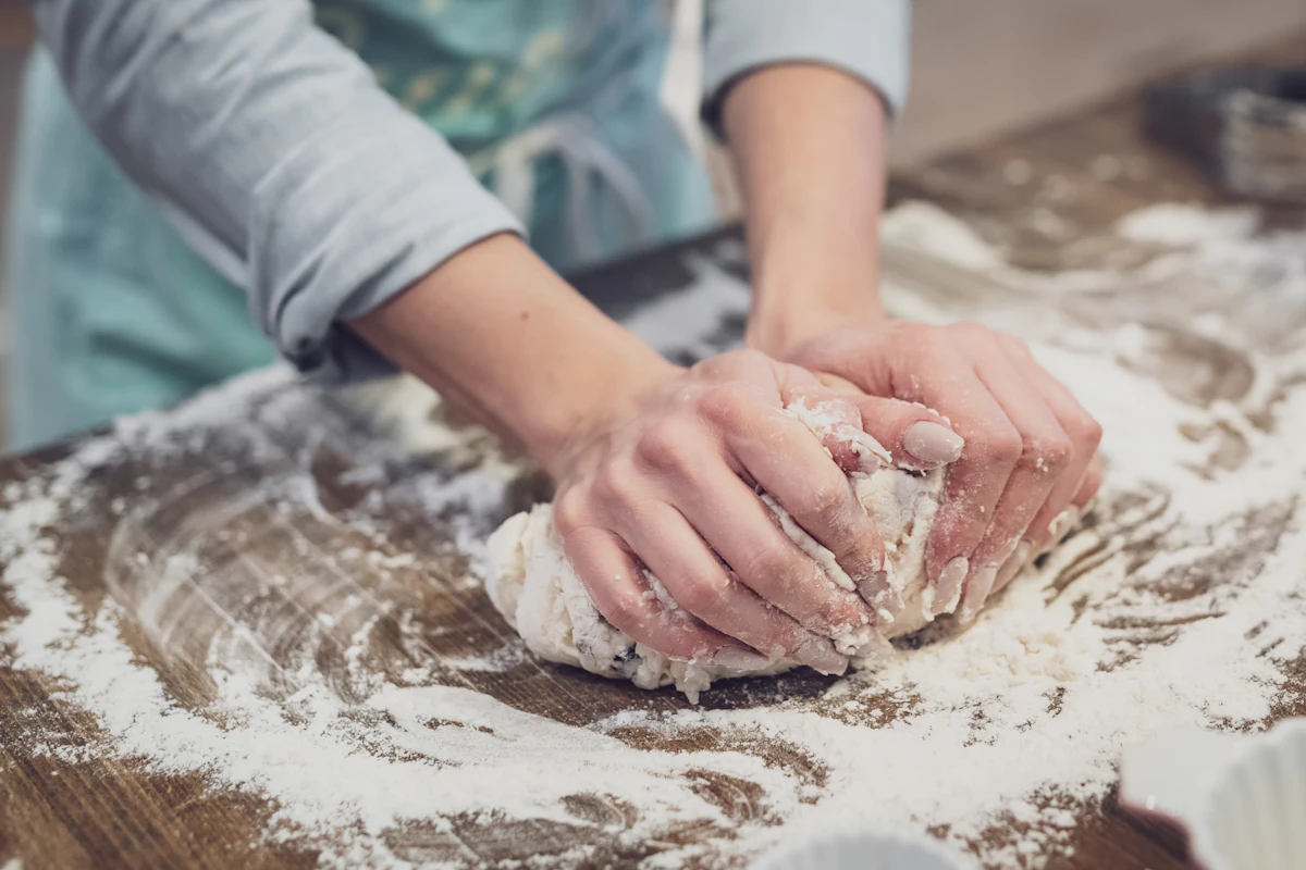 Teig wird auf einer bemehlten Arbeitsfläche geknetet